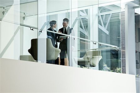 simsearch:6118-09129618,k - Businessman and woman standing behind a conference room window in large business centre. Photographie de stock - Premium Libres de Droits, Code: 6118-09129625