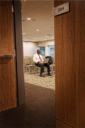 simsearch:6118-09139986,k - Black businessman in a conference centre meeting space working on lap top. Foto de stock - Sin royalties Premium, Código: 6118-09129634