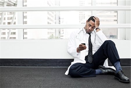 simsearch:6118-09129710,k - Black man doctor stressed out and sitting on floor. Stockbilder - Premium RF Lizenzfrei, Bildnummer: 6118-09129703