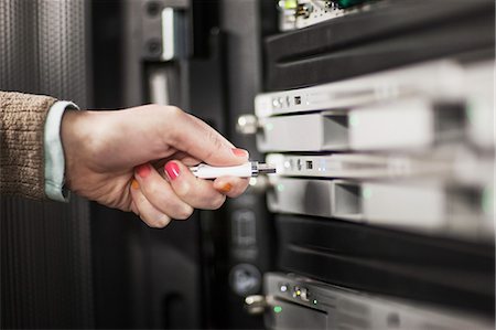 simsearch:6118-09129858,k - Computer technician inserting thumb drive into a server in a server farm. Foto de stock - Sin royalties Premium, Código: 6118-09129839