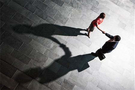 simsearch:6118-09129966,k - View from above of a handshake and shadows between a businessman and business woman. Stock Photo - Premium Royalty-Free, Code: 6118-09129967