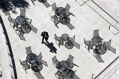 View from above of a businessman on his phone standing on a cafe terrace. Photographie de stock - Premium Libres de Droits, Code: 6118-09129985