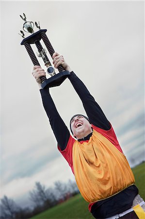 simsearch:832-03640620,k - Caucasian man celebrating a sporting event win with a trophy. Foto de stock - Royalty Free Premium, Número: 6118-09130017