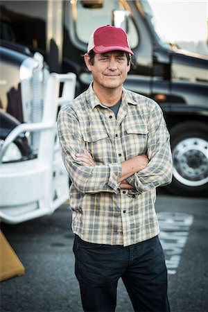 Caucasian man truck driver with his truck parked in a lot at a truck stop. Stockbilder - Premium RF Lizenzfrei, Bildnummer: 6118-09139345