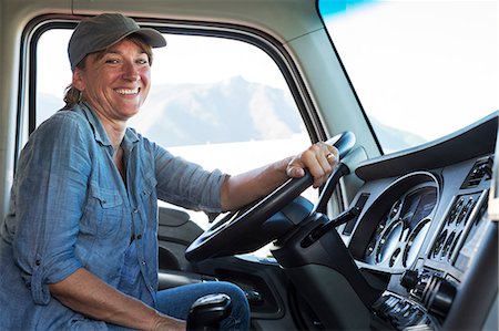 Caucasian woman truck driver in the cab of her commercial truck at a truck stop Photographie de stock - Premium Libres de Droits, Code: 6118-09139360