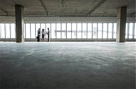 simsearch:6118-09139404,k - Group of business people looking at a new empty raw office space. Photographie de stock - Premium Libres de Droits, Code: 6118-09139398