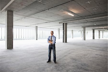 futuristic offices - Asian businessman in a new empty raw office space. Stock Photo - Premium Royalty-Free, Code: 6118-09139415