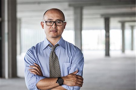 simsearch:6118-09139404,k - Asian businessman taking a look at a large empty raw office space. Photographie de stock - Premium Libres de Droits, Code: 6118-09139421