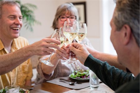 simsearch:6118-08659835,k - Senior couples toasting a home dinner party with glasses of white wine. Foto de stock - Sin royalties Premium, Código: 6118-09139584