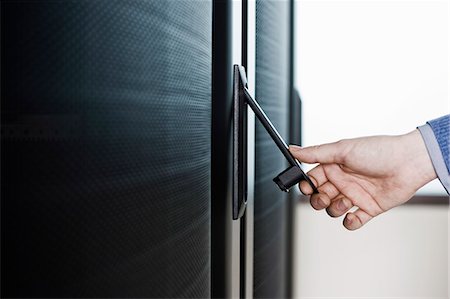 simsearch:6118-09139635,k - Opening the door to a rack holding servers in a computer server farm. Stockbilder - Premium RF Lizenzfrei, Bildnummer: 6118-09139657