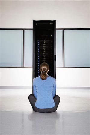 simsearch:6118-09139635,k - Woman lab technician sitting in front of a rack for servers in a computer server farm. Stockbilder - Premium RF Lizenzfrei, Bildnummer: 6118-09139659