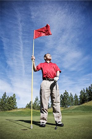 senior japanese golfer - A senior golfer ready to approach the next shot on a golf course. Stock Photo - Premium Royalty-Free, Code: 6118-09139697