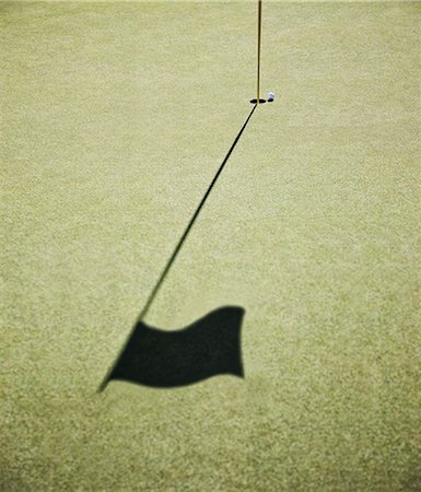 simsearch:6118-09144991,k - Shadow of a golf flag on the green of a golf course. Stock Photo - Premium Royalty-Free, Code: 6118-09139696