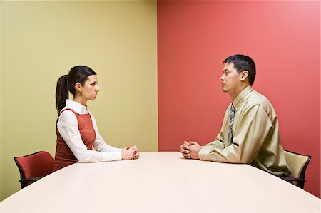 simsearch:6118-09139986,k - Businessman and woman sitting on opposite sides of a conference table in a very colourful room. Foto de stock - Sin royalties Premium, Código: 6118-09139611
