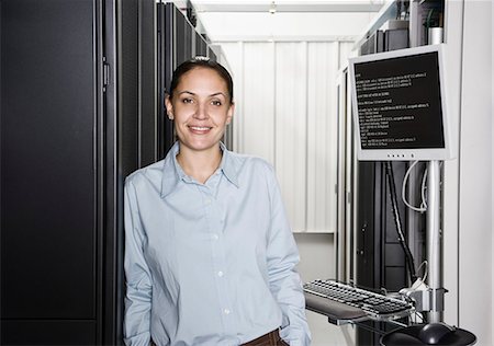 simsearch:6118-09139628,k - A Caucasian woman computer technician working on servers in a computer server farm. Foto de stock - Sin royalties Premium, Código: 6118-09139629