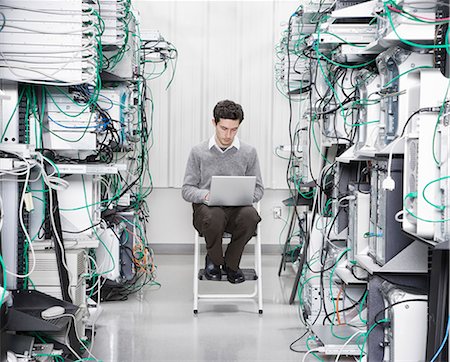 simsearch:6118-09139628,k - Caucasian male technician working on computer servers in a computer server farm. Foto de stock - Sin royalties Premium, Código: 6118-09139634