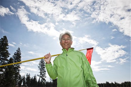 simsearch:6118-09144991,k - A young Asian senior man ready to hit his next golf shot on a golf course. Stock Photo - Premium Royalty-Free, Code: 6118-09139772