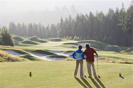 simsearch:6118-09144991,k - Senior golfing couple surveying the next tee shot toward the green. Stock Photo - Premium Royalty-Free, Code: 6118-09139783