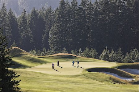 simsearch:6118-09144991,k - View from above of four golfers playing golf on a green in the distance. Stock Photo - Premium Royalty-Free, Code: 6118-09139781