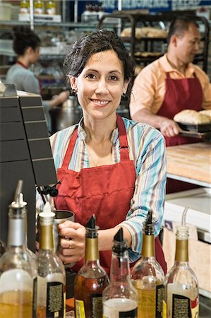 standing - Hispanic woman at the cash register of a bakery/coffee shop. Stock Photo - Premium Royalty-Free, Code: 6118-09139798
