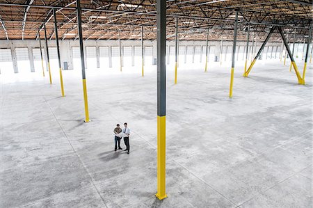 simsearch:6118-09166274,k - Team of people checking out the new interior of an empty warehouse space. Photographie de stock - Premium Libres de Droits, Code: 6118-09139942