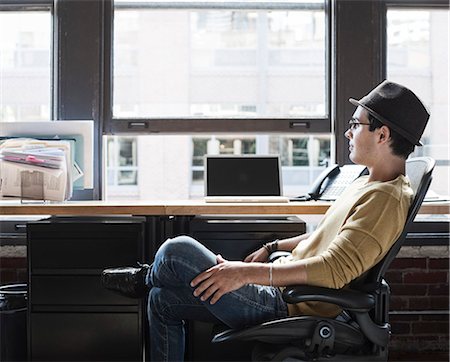 simsearch:6118-09139986,k - Hispanic male at his office workstation in a creative office. Foto de stock - Sin royalties Premium, Código: 6118-09139984