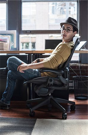 simsearch:6118-09147986,k - Hispanic male at his office workstation in a creative office. Fotografie stock - Premium Royalty-Free, Codice: 6118-09139985