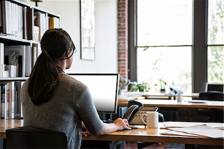 simsearch:6118-09139986,k - Asian woman working at her desk in a creative office. Foto de stock - Sin royalties Premium, Código: 6118-09139989