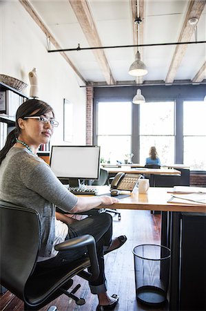 simsearch:6118-09139986,k - Asian woman working at her desk in a creative office. Foto de stock - Sin royalties Premium, Código: 6118-09139993