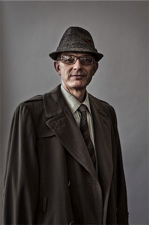 sinister smile - Studio portrait of Caucasian man actor with a hat and overcoat on. Stock Photo - Premium Royalty-Free, Code: 6118-09139903