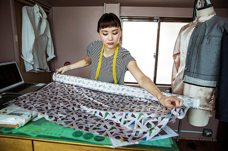 Japanese female fashion designer working in her studio, measuring fabric. Stock Photo - Premium Royalty-Free, Code: 6118-09200177