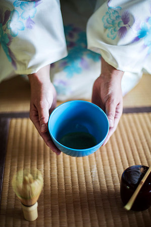 simsearch:6118-09200284,k - High angle close up of Japanese woman wearing traditional white kimono with blue floral pattern kneeling on floor during tea ceremony, holding blue tea bowl. Stock Photo - Premium Royalty-Free, Code: 6118-09200245