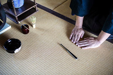 simsearch:6118-09200284,k - High angle close up of Japanese man kneeling on tatami mat in front of Sensu fan, bowl and whisk used in tea ceremony. Stock Photo - Premium Royalty-Free, Code: 6118-09200254