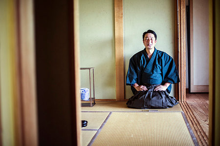 simsearch:6118-09200284,k - Japanese man wearing kimono kneeling on floor, on a tatami mat during tea ceremony. Stock Photo - Premium Royalty-Free, Code: 6118-09200264