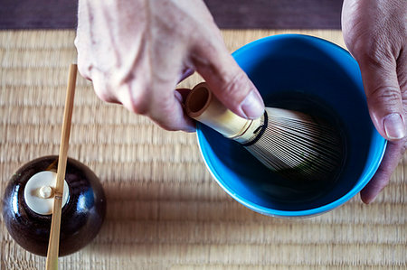 simsearch:6118-09200260,k - High angle close up of person using bamboo whisk to prepare Matcha tea in a blue bowl during tea ceremony. Photographie de stock - Premium Libres de Droits, Code: 6118-09200228