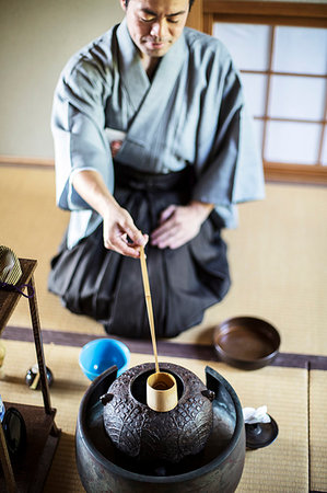 simsearch:632-05992254,k - Traditional Japanese Tea Ceremony, man wearing kimono sitting on floor, using a Hishaku, a bamboo ladle, to pour hot water. Photographie de stock - Premium Libres de Droits, Code: 6118-09200238