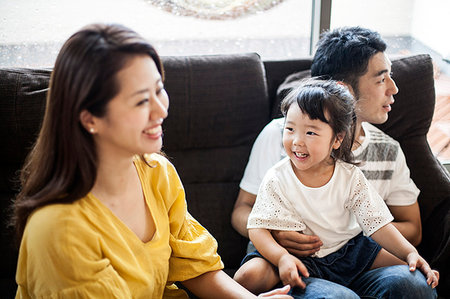 simsearch:6118-09079298,k - Portrait of smiling Japanese man, woman and young girl sitting on a sofa. Photographie de stock - Premium Libres de Droits, Code: 6118-09200370