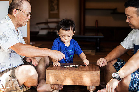 simsearch:693-07455844,k - Two Japanese men and little boy sitting on floor on porch of traditional Japanese house, playing Go. Stock Photo - Premium Royalty-Free, Code: 6118-09200339