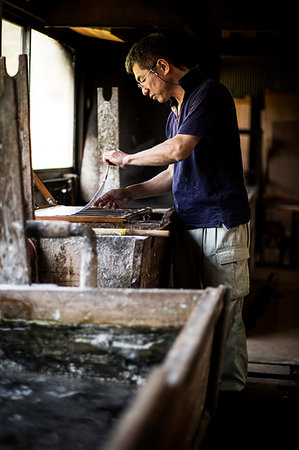 simsearch:6118-08761878,k - Japanese man in a workshop, holding a wooden frame with pressed pulp, making traditional Washi paper. Photographie de stock - Premium Libres de Droits, Code: 6118-09200404