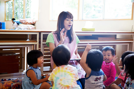 Female teacher telling story to group of children in a Japanese preschool. Stock Photo - Premium Royalty-Free, Code: 6118-09200533