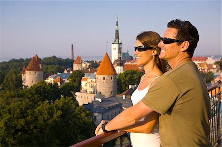 A couple take in the views of lower Old Town with Oleviste Church in the background, Tallinn, Estonia, Europe Stock Photo - Premium Royalty-Free, Code: 6119-07451493
