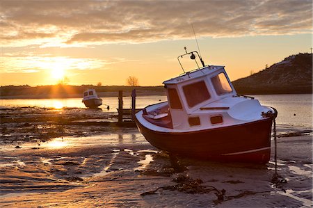 View towards the Aln Estuary during a stunning winter sunrise from the beach at low tide with a fishing boat in the foreground, Alnmouth, near Alnwick, Northumberland, England, United Kingdom, Europe Photographie de stock - Premium Libres de Droits, Code: 6119-07744609