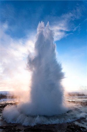 Strokkur Geysir erupting at sunrise on a freezing winter's morning against the colourful sky, Geysir, Haukardalur Valley, Iceland, Polar Regions Foto de stock - Sin royalties Premium, Código: 6119-07781127