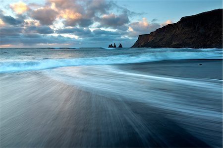 Looking towards the sea stacks of Reynisdrangar at sunrise from the black volcanic sand beach at Vik i Myrdal, South Iceland, Polar Regions Stock Photo - Premium Royalty-Free, Code: 6119-07781129