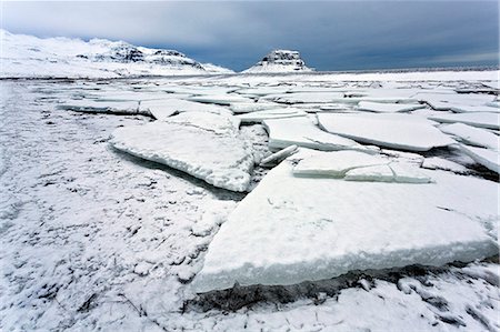 Winter view over slabs of broken lake ice covered in snow towards Kirkjufell (Church Mountain), near Grundarfjordur, Snaefellsnes Peninsula, Iceland, Polar Regions Stock Photo - Premium Royalty-Free, Code: 6119-07781136