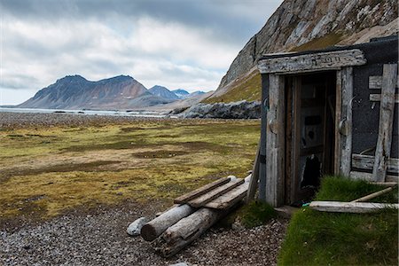 Abandoned hut on Alkhornet with a huge rock in the background, Svalbard, Arctic Photographie de stock - Premium Libres de Droits, Code: 6119-07968966