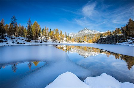 The peaks of Valmalenco in Valtellina reflecting in the water of the half frozen Lake Mufule, Lombardy, Italy, Europe Foto de stock - Sin royalties Premium, Código: 6119-08062042