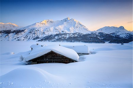 swiss alps - Some scattered huts in a snowy landscape at Spluga by the Maloja Pass with the magical colors of the sunset, Graubunden, Swiss Alps, Switzerland, Europe Foto de stock - Sin royalties Premium, Código: 6119-08062106