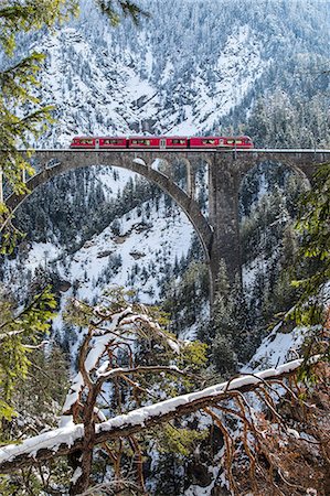 The Bernina Express crossing the Wiesen Viaduct in the Swiss Canton of Graubunden, Switzerland, Europe Photographie de stock - Premium Libres de Droits, Code: 6119-08062136