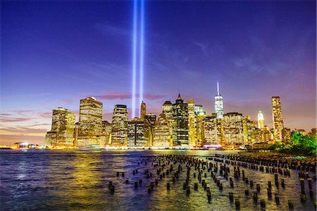 Lower Manhattan skyscrapers including One World Trade Center from across the East River at night, with light beams from the Tribute in Light 9/11 Memorial, New York City, New York, United States of America, North America Stock Photo - Premium Royalty-Free, Code: 6119-08062346